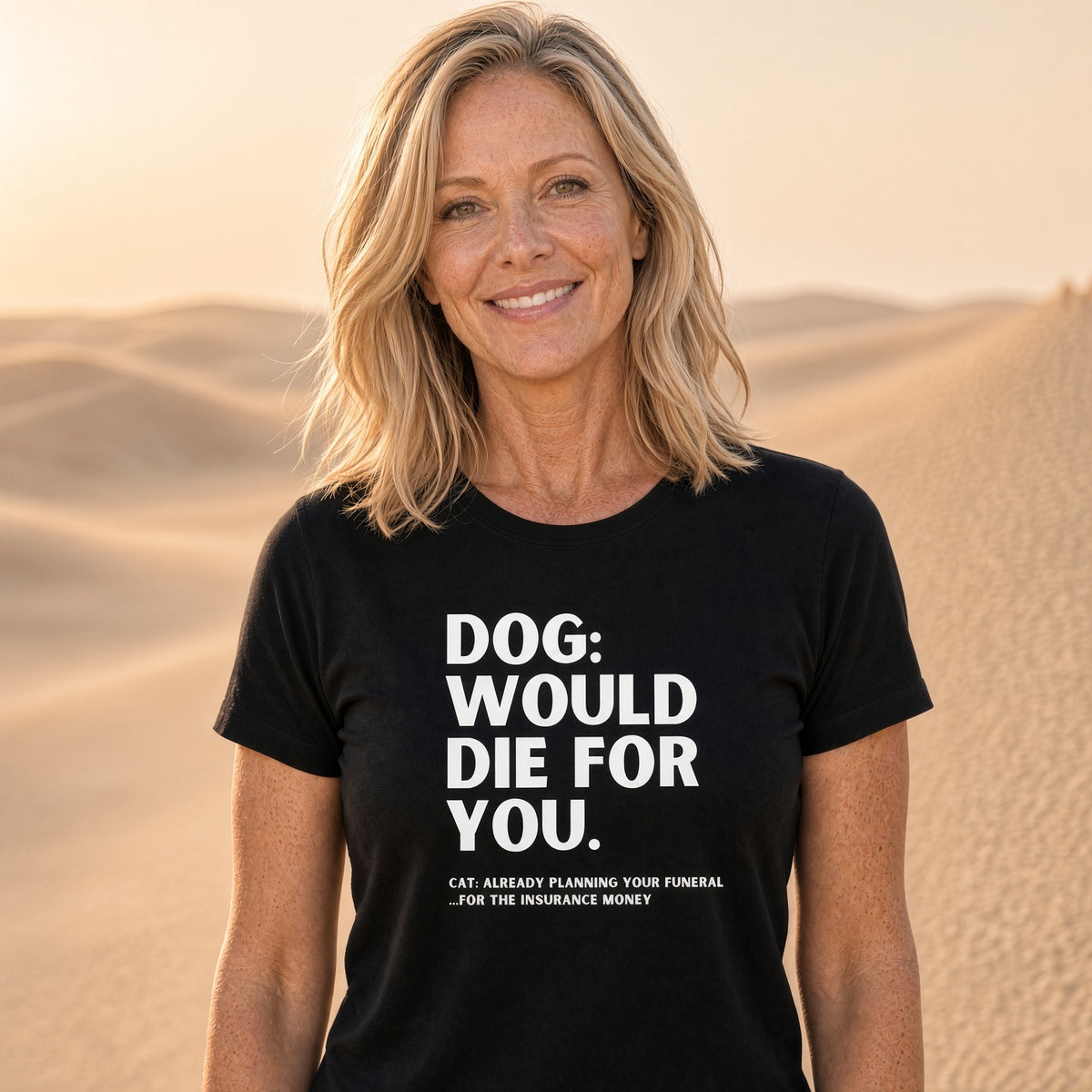 Woman wearing a black t-shirt with humorous dog vs cat text in a desert setting.