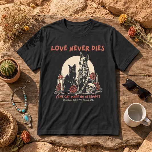 Flat lay of a black t-shirt featuring a cat skeleton design, surrounded by decorative items.