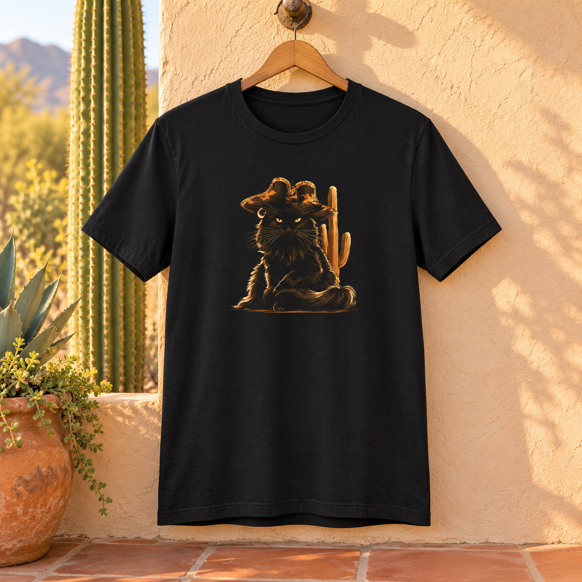 Black t-shirt featuring a pirate cat design hanging on a wall in a desert environment.