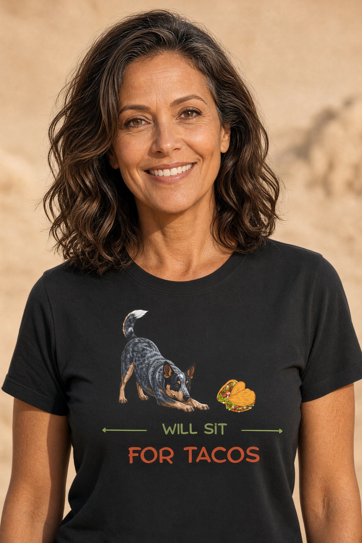 Woman wearing a black t-shirt featuring a blue heeler dog and tacos with the text 'WILL SIT FOR TACOS'.