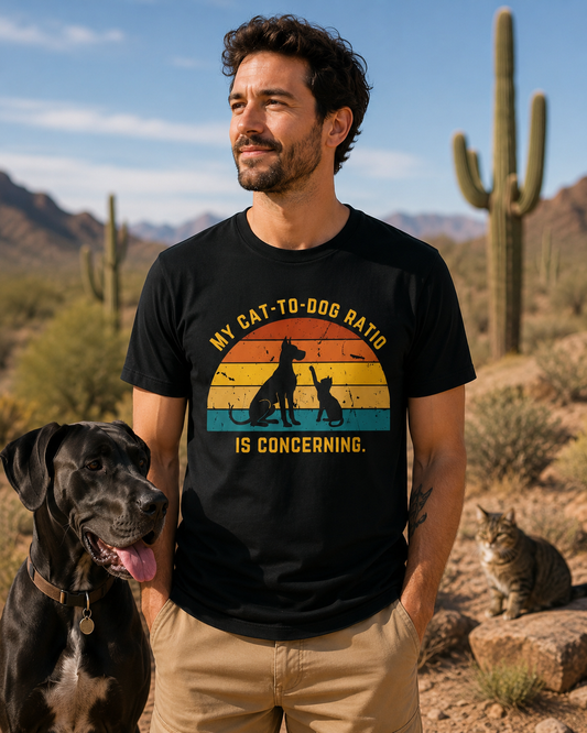 Man wearing a black My Cat-to-Dog Ratio Is Concerning shirt in a desert landscape with a black dog and a cat nearby.