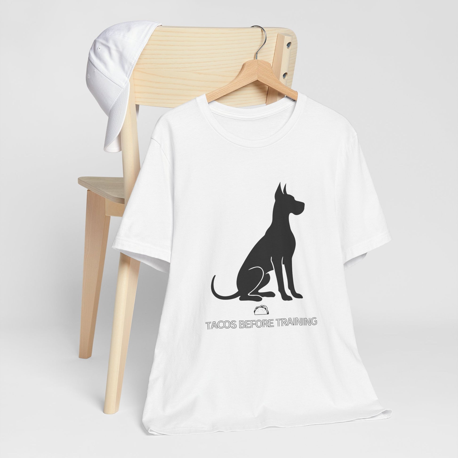 White t-shirt with white Great Dane silhouette and text reading Tacos Before Training