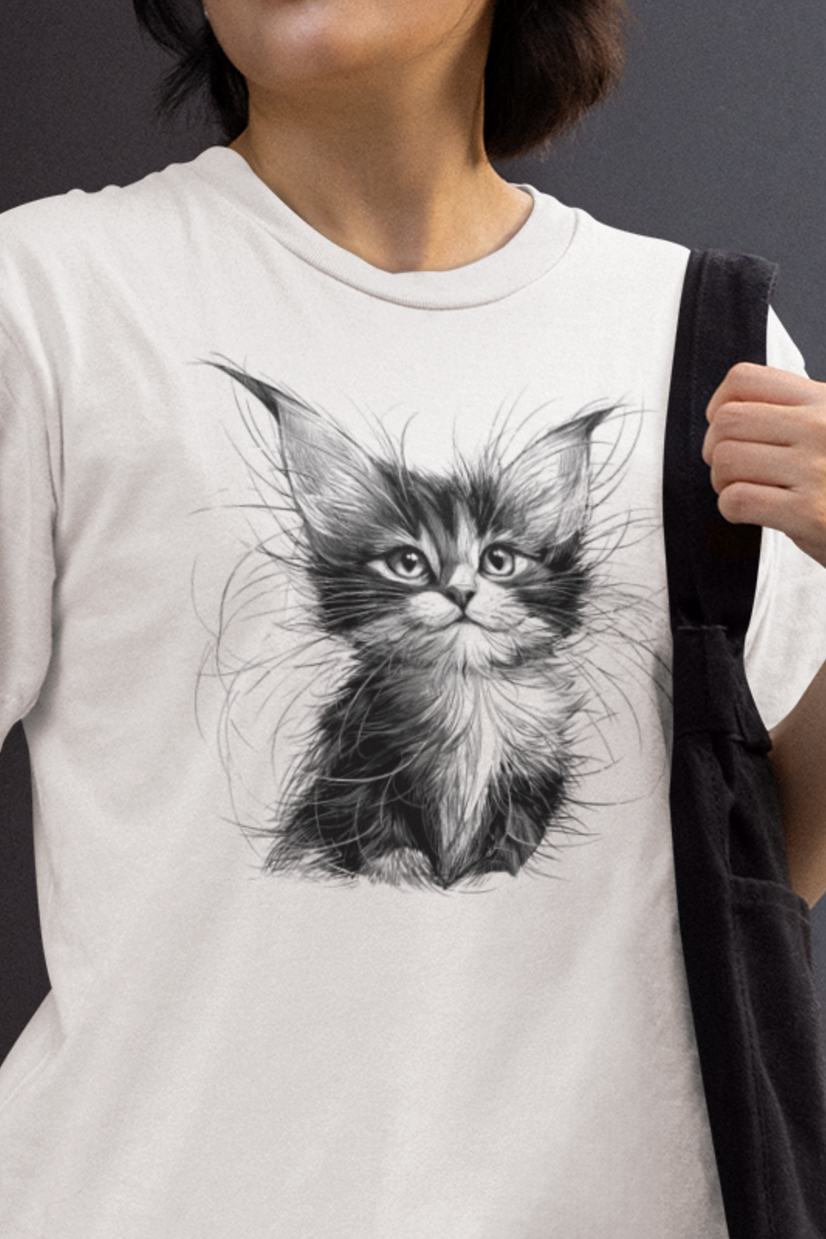 Person wearing a Black & White Kitten Sketch Tee with fluffy rescue kitten portrait on white unisex t-shirt