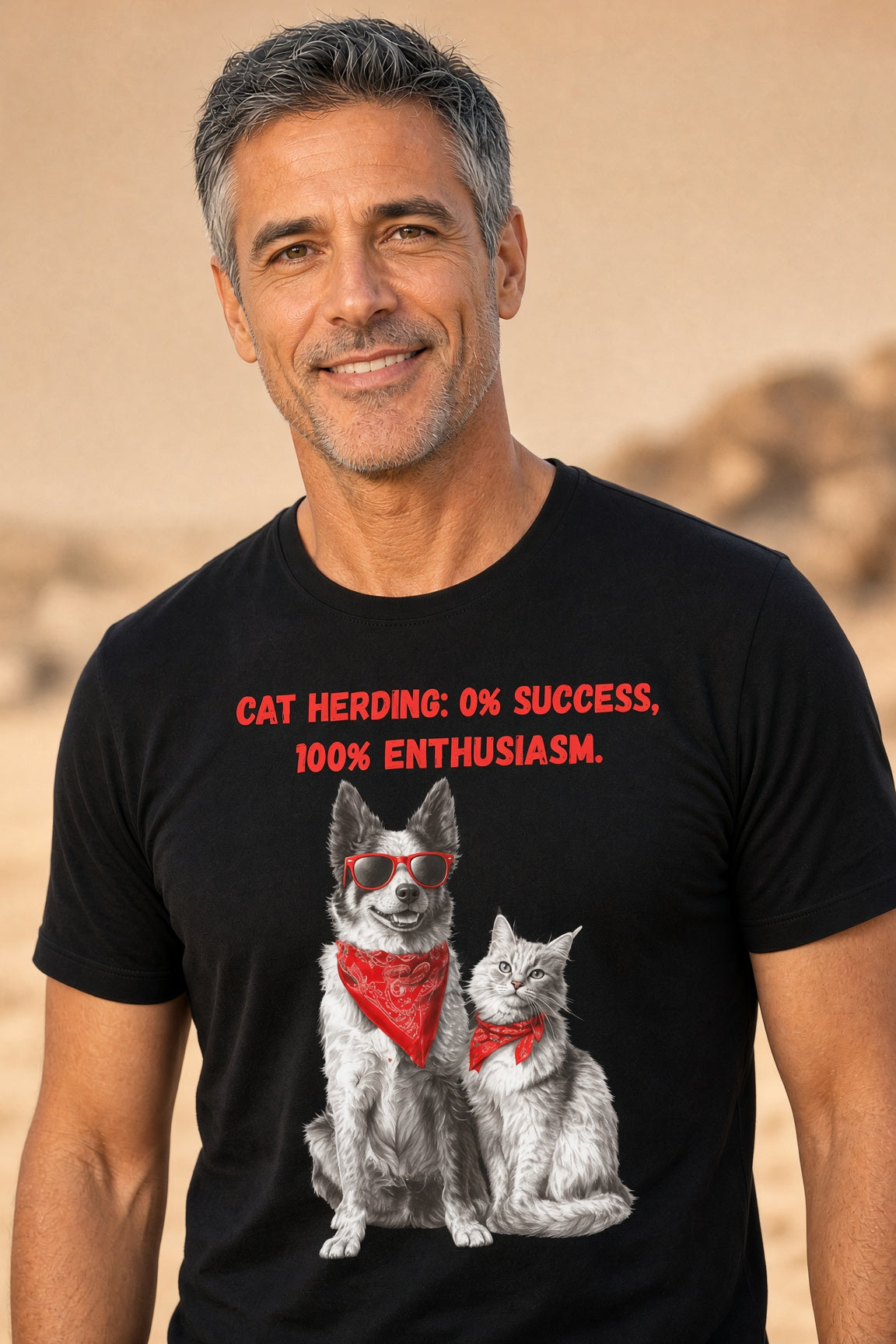 Man wearing a black t-shirt featuring a dog and cat with sunglasses and red bandanas, text reads 'Cat Herding: 0% Success, 100% Enthusiasm.'