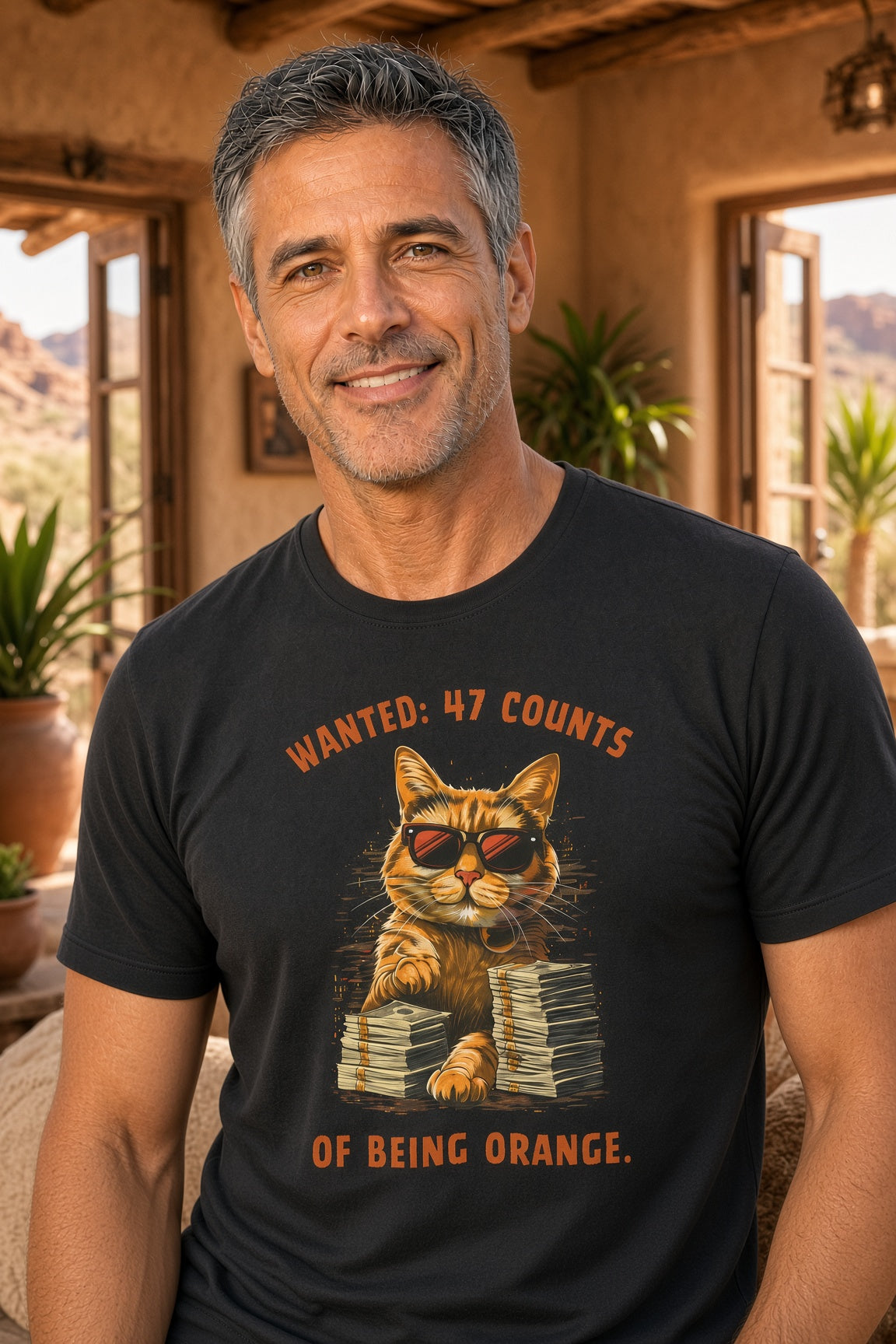 Man wearing a black t-shirt featuring a cat in sunglasses with the text 'Wanted: 47 Counts of Being Orange.'