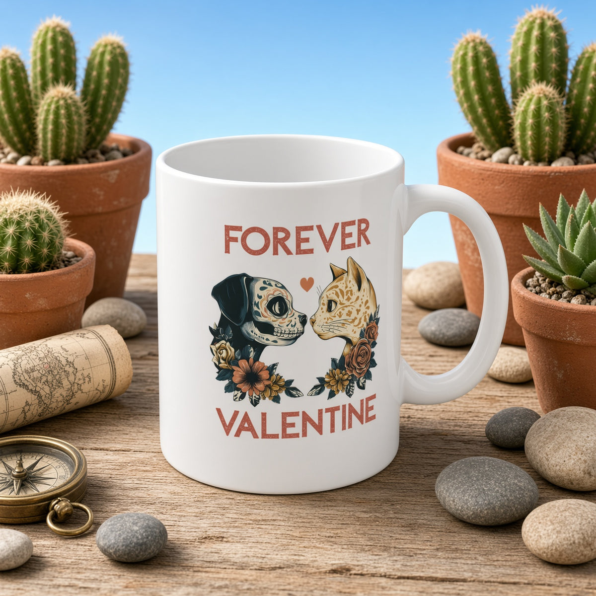 White mug featuring a dog and cat illustration, placed among pebbles and potted plants with the caption 'FOREVER VALENTINE'.