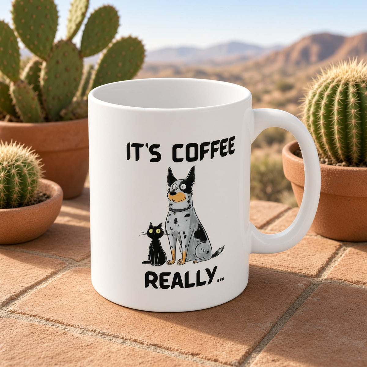 White mug featuring a blue heeler dog and a black cat with the text 'IT'S COFFEE REALLY...' in a desert setting.