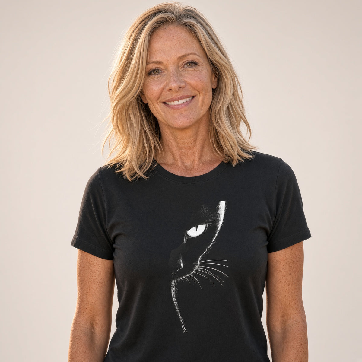 Woman with a friendly smile wearing a black cat graphic t-shirt against a light background.