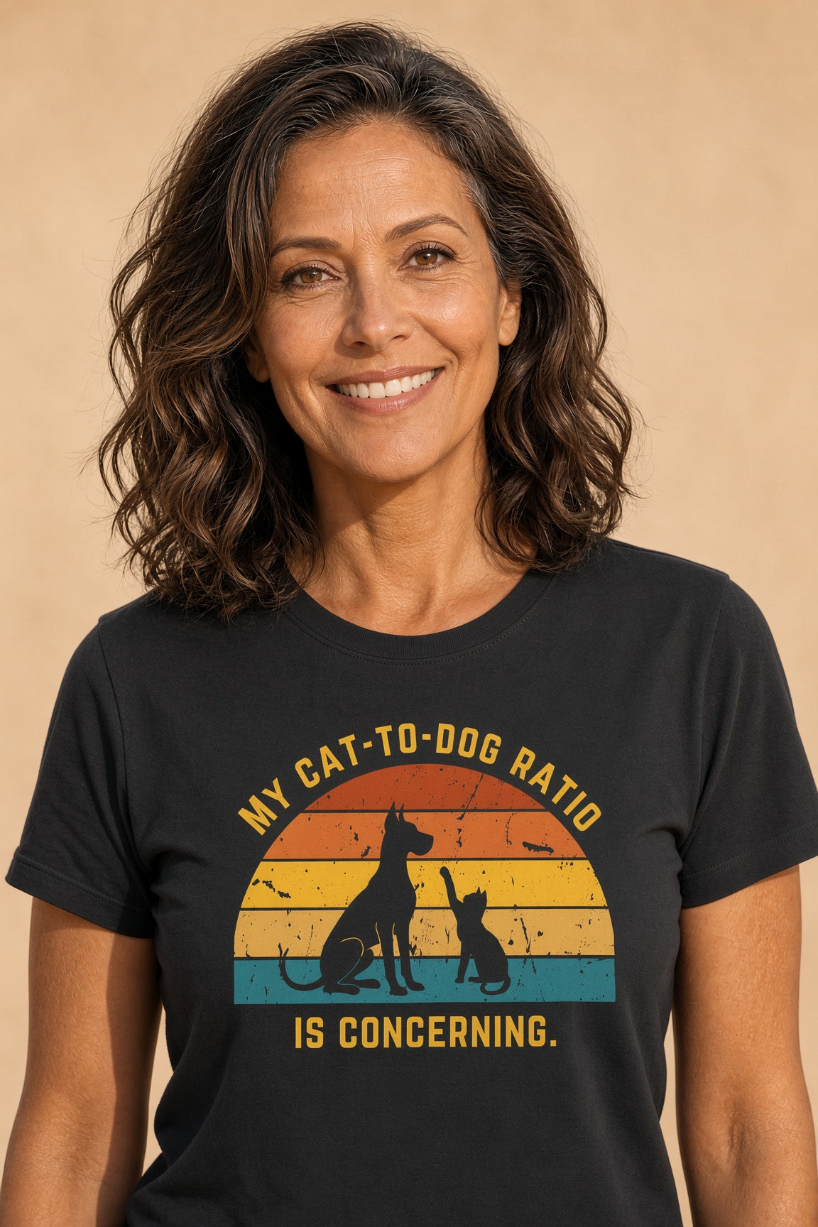 Woman smiling while wearing a black t-shirt with a retro design of a dog and cat silhouette and the text 'My Cat-to-Dog Ratio Is Concerning.'