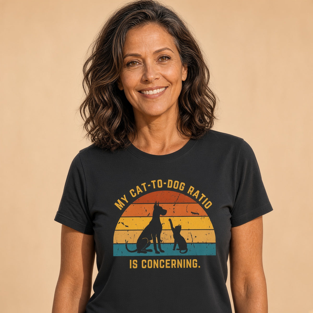 Woman smiling while wearing a black t-shirt with a retro pet design featuring a cat and dog and the text 'My Cat-to-Dog Ratio Is Concerning.'