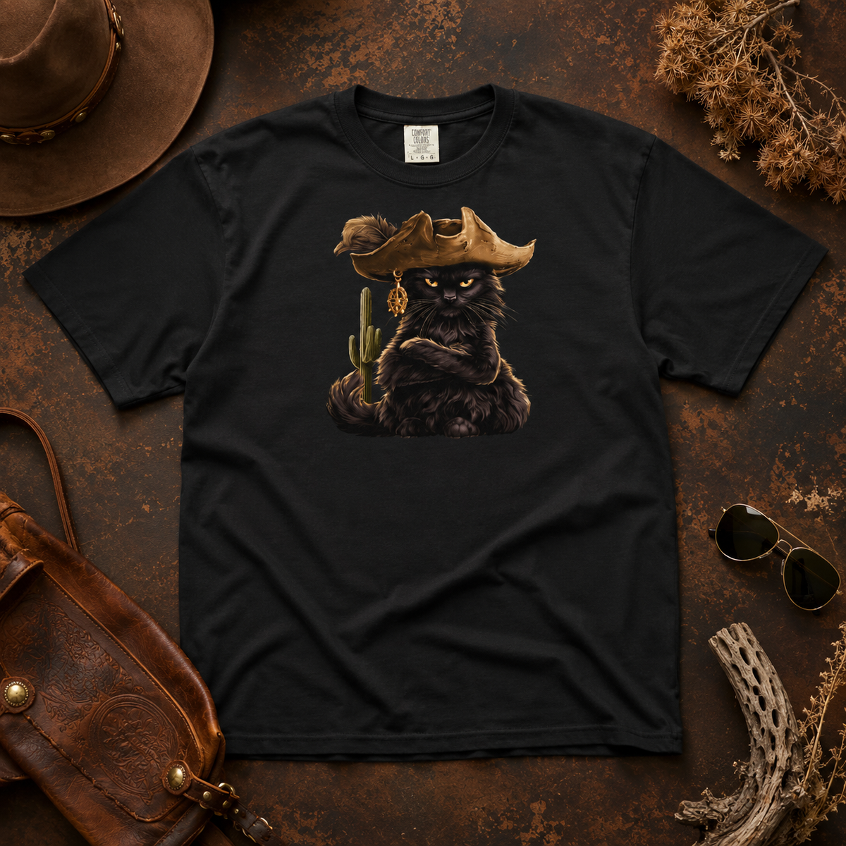 Black tee featuring a pirate cat design on a rustic background with accessories.