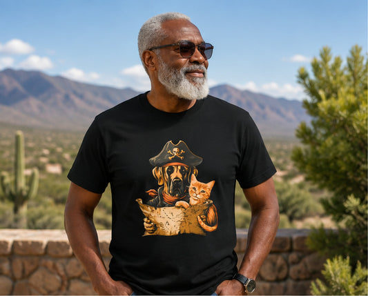 Man wearing a black tee with a pirate dog and cat design in a desert landscape.