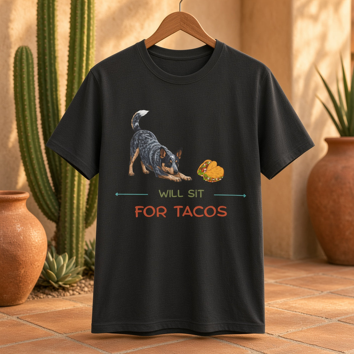 Black t-shirt featuring a Blue Heeler and taco graphic with the text 'WILL SIT FOR TACOS' in a desert setting.