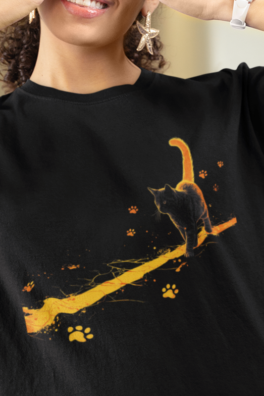 Chaos on a Hot Streak Stray Tee black cat graphic shirt with glowing orange trail and paw prints, worn by a person.