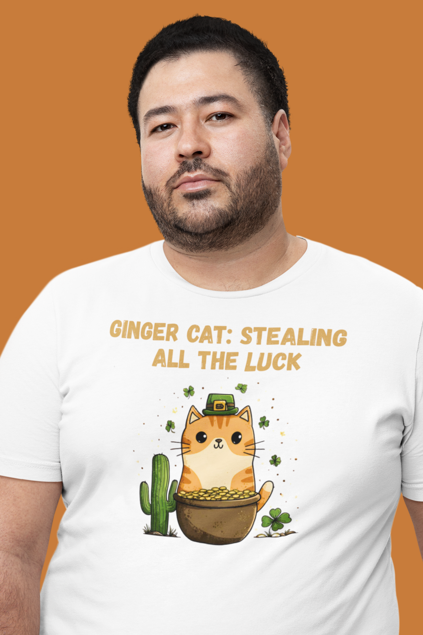 White t-shirt with ginger cat in pot of gold, shamrocks, saguaro cactus, text ‘Ginger Cat: Stealing All the Luck