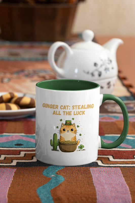 Ginger Cat Stealing All the Luck St. Patrick’s Day mug with orange tabby, pot of gold, shamrocks and saguaro cactus, green handle