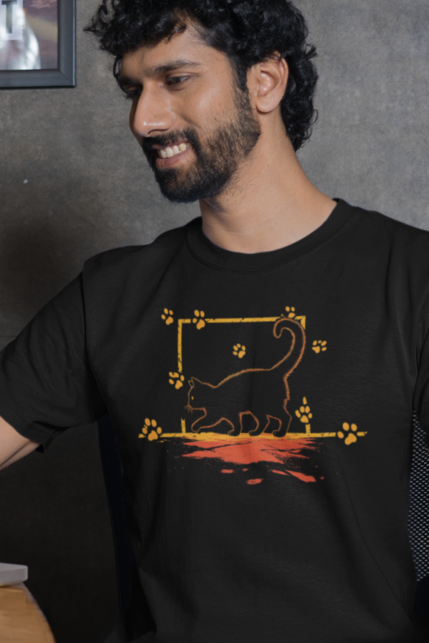 Man wearing a black t-shirt with a graphic design of a lion and paw prints.